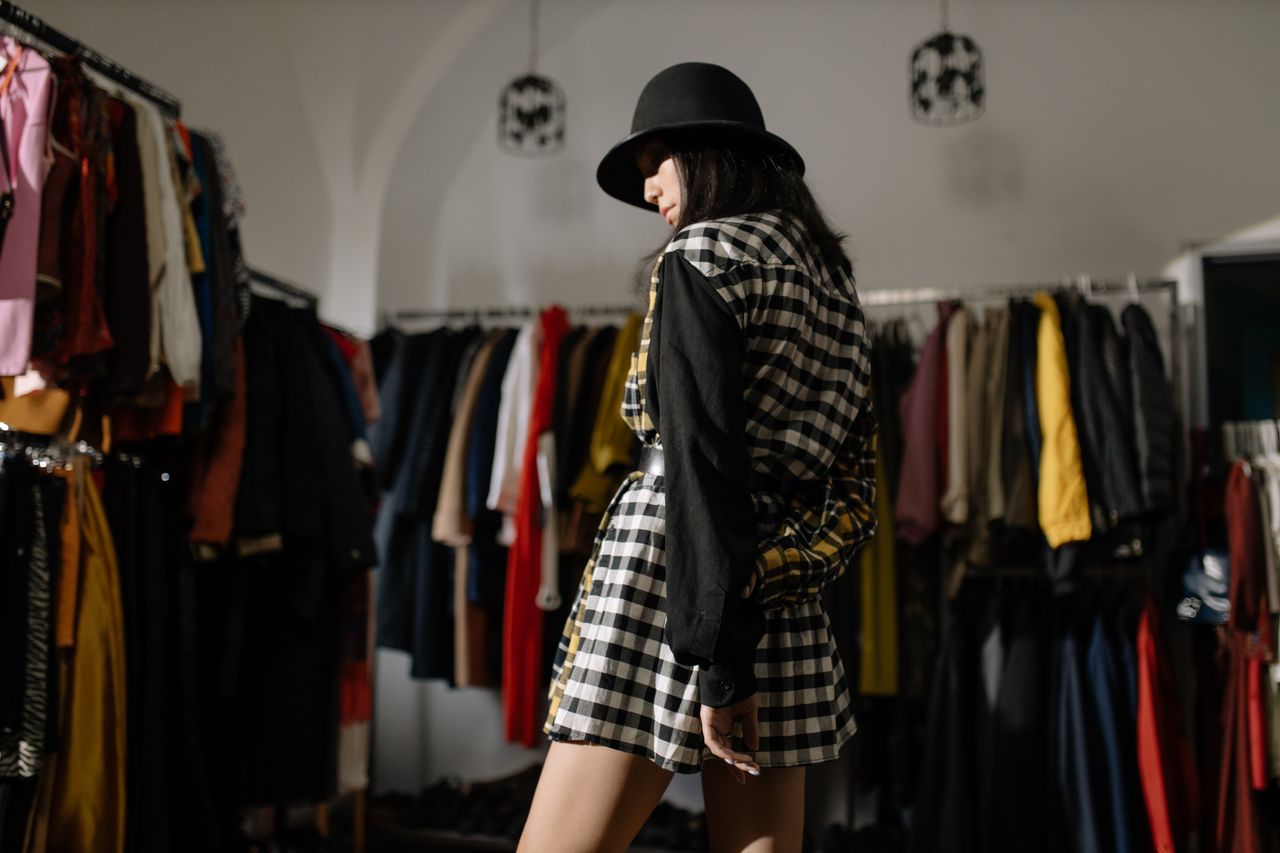 Trendy woman in stylish outfit exploring fashionable clothing store layout.